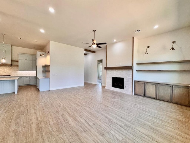 10165 NW 100th St, Yukon, OK 73099 - unfurnished living room with ceiling fan, a fireplace, light wood-type flooring, and recessed lighting