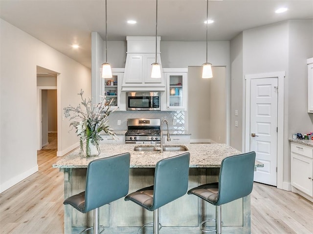 5512 Cheyenne Rd, Warr Acres, OK 73132 - kitchen featuring appliances with stainless steel finishes, light wood-type flooring, light stone counters, white cabinets, and decorative backsplash