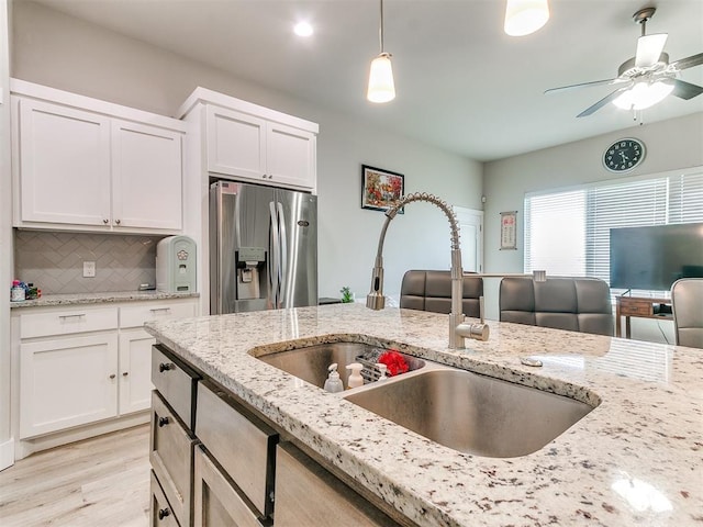 5512 Cheyenne Rd, Warr Acres, OK 73132 - kitchen featuring stainless steel fridge with ice dispenser, backsplash, light wood-type flooring, and white cabinetry