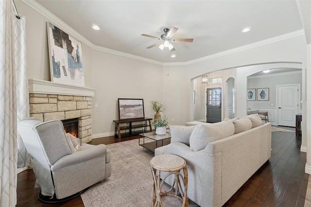 917 NW 186th St, Edmond, OK 73012 - living area with arched walkways, a ceiling fan, dark wood finished floors, ornamental molding, and a fireplace