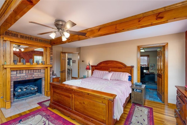 498 Big Horn Rd, Mcalester, OK 74501 - bedroom featuring light wood-style floors, a fireplace, and a ceiling fan