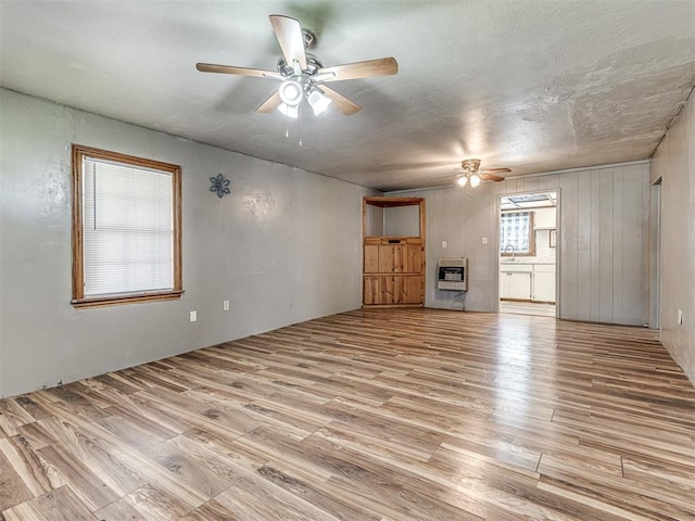 211 S 6th St, Mcloud, OK 74851 - unfurnished living room with a ceiling fan, wood finished floors, and heating unit