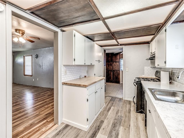 211 S 6th St, Mcloud, OK 74851 - kitchen with a sink, light wood finished floors, gas range, and light countertops