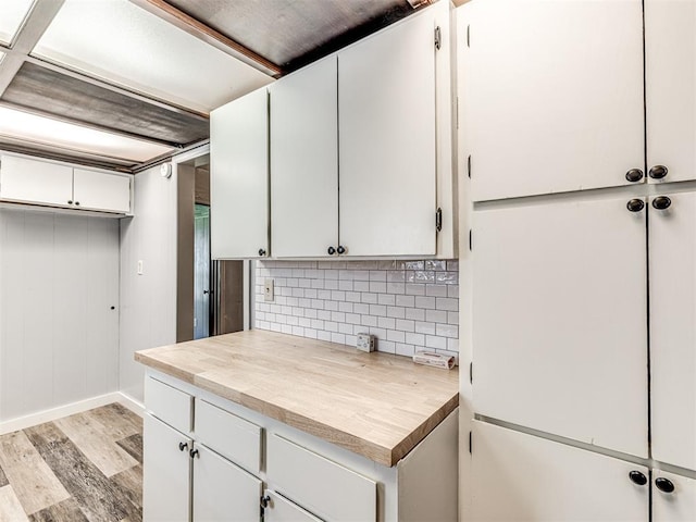 211 S 6th St, Mcloud, OK 74851 - kitchen with tasteful backsplash, light wood finished floors, white cabinetry, and baseboards