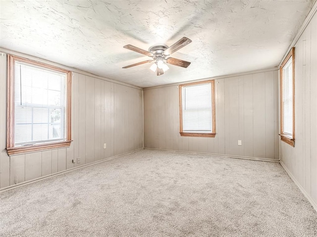 211 S 6th St, Mcloud, OK 74851 - empty room with ceiling fan, plenty of natural light, carpet, and a textured ceiling