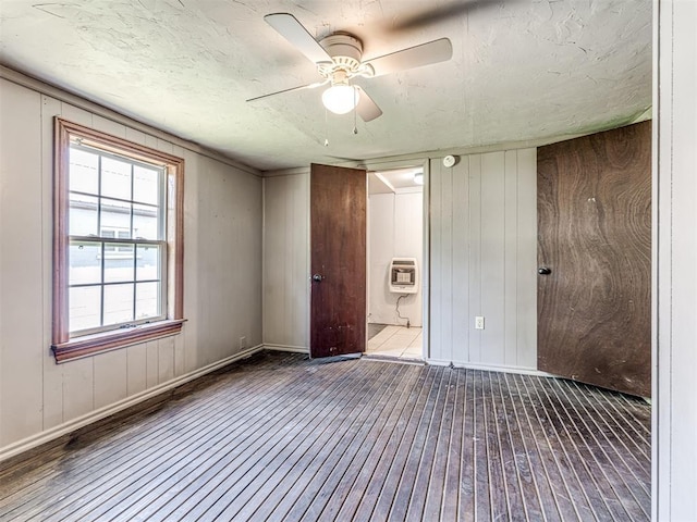 211 S 6th St, Mcloud, OK 74851 - unfurnished bedroom featuring hardwood / wood-style flooring, baseboards, heating unit, and wooden walls