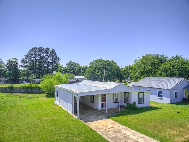 211 S 6th St, Mcloud, OK 74851 - view of front of house featuring concrete driveway, metal roof, a front yard, and an attached carport