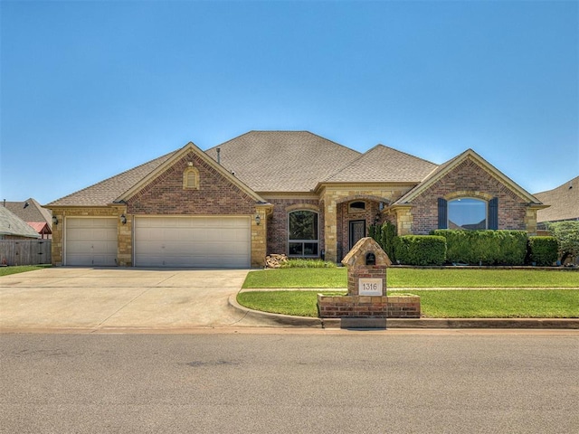 1316 NW 171st St, Edmond, OK 73012 - french country inspired facade with brick siding, a garage, a front lawn, driveway, and a shingled roof