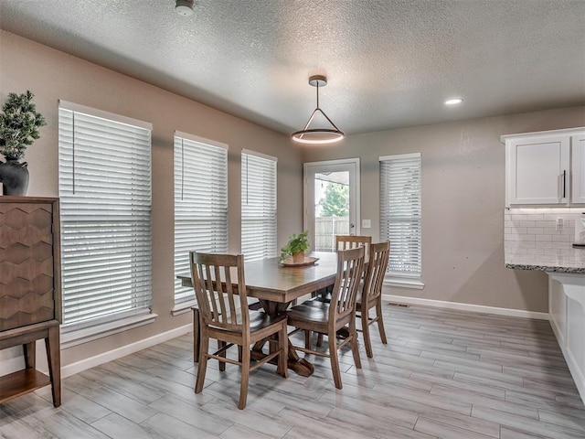 6513 NW 95th St, Oklahoma City, OK 73162 - dining room with baseboards, a textured ceiling, and light wood finished floors