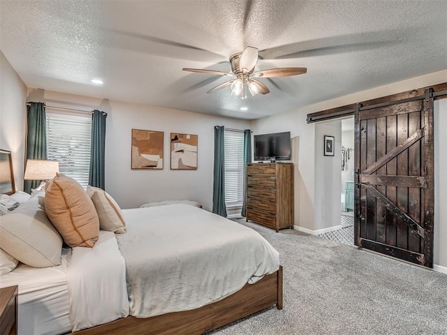 6513 NW 95th St, Oklahoma City, OK 73162 - bedroom featuring a barn door, carpet, a textured ceiling, ceiling fan, and baseboards