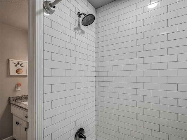 6513 NW 95th St, Oklahoma City, OK 73162 - bathroom with tiled shower, vanity, and a textured ceiling
