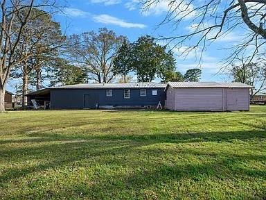309 E Memorial St, Broken Bow, OK 74728 - back of house featuring a yard and an outbuilding