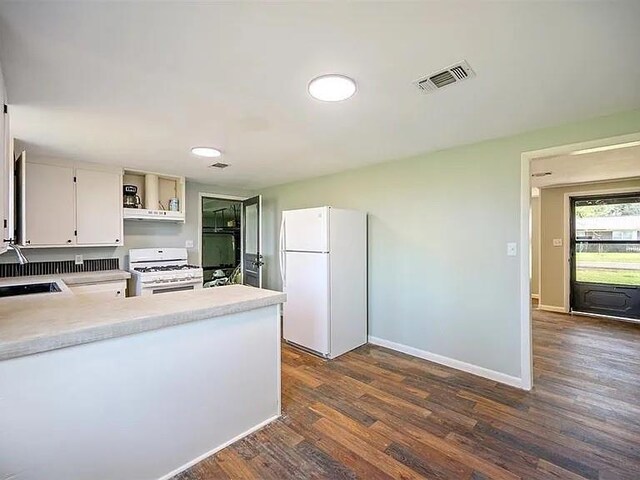 309 E Memorial St, Broken Bow, OK 74728 - kitchen featuring white appliances, open shelves, light countertops, dark wood-style flooring, and baseboards