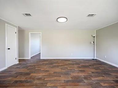 309 E Memorial St, Broken Bow, OK 74728 - empty room featuring wood finished floors and baseboards