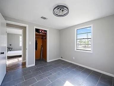 309 E Memorial St, Broken Bow, OK 74728 - unfurnished bedroom featuring baseboards and a closet