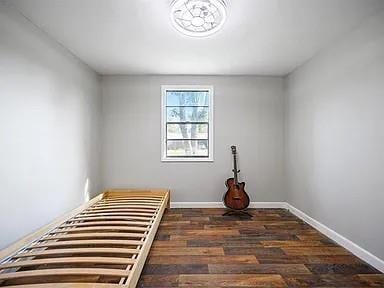 309 E Memorial St, Broken Bow, OK 74728 - spare room featuring baseboards and wood finished floors