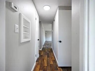 309 E Memorial St, Broken Bow, OK 74728 - hallway featuring baseboards and dark wood-style flooring