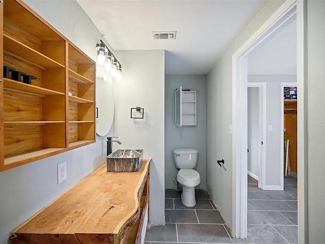309 E Memorial St, Broken Bow, OK 74728 - bathroom with tile patterned floors, toilet, and vanity