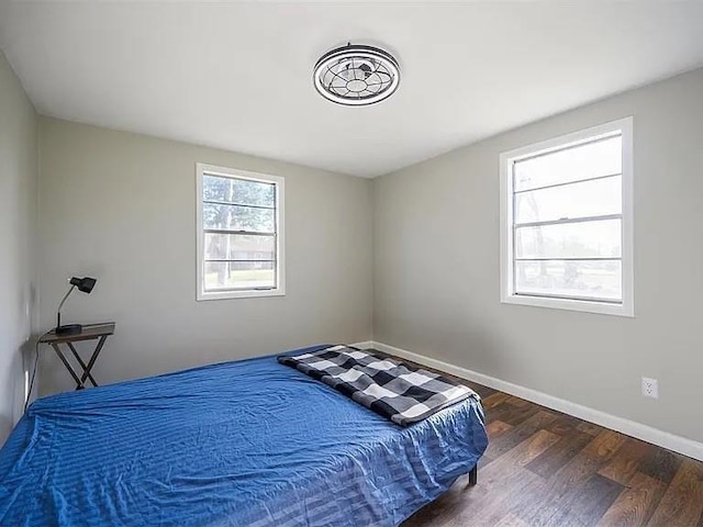 309 E Memorial St, Broken Bow, OK 74728 - bedroom featuring dark wood-style flooring and baseboards