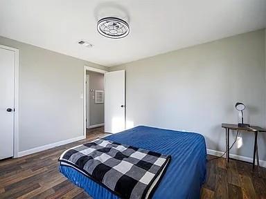 309 E Memorial St, Broken Bow, OK 74728 - bedroom featuring wood finished floors and baseboards