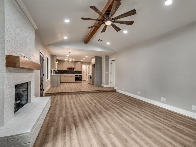 16101 S Rock Creek Rd, Shawnee, OK 74801 - unfurnished living room with recessed lighting, ceiling fan, a chandelier, a fireplace, and light wood-style flooring