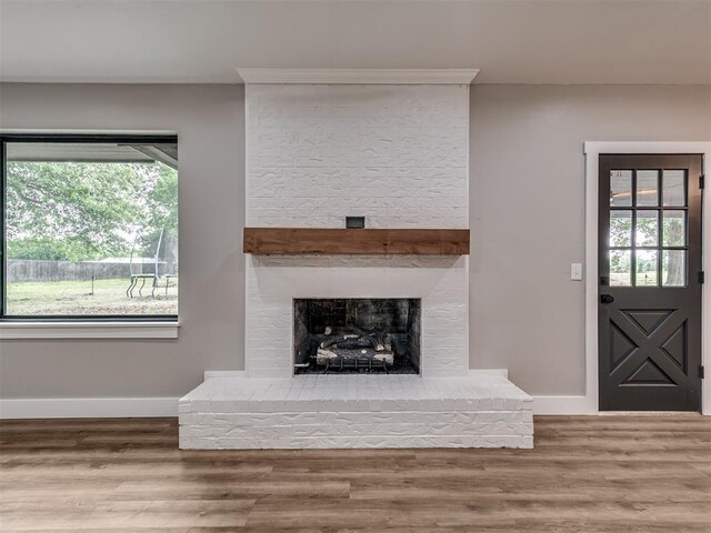 16101 S Rock Creek Rd, Shawnee, OK 74801 - unfurnished living room featuring baseboards, wood finished floors, and a fireplace