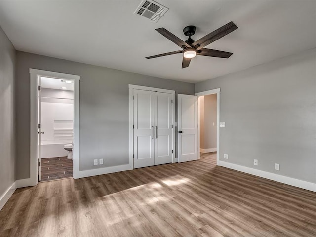 16101 S Rock Creek Rd, Shawnee, OK 74801 - unfurnished bedroom with baseboards, wood finished floors, ensuite bathroom, a closet, and ceiling fan