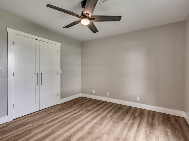 16101 S Rock Creek Rd, Shawnee, OK 74801 - unfurnished bedroom featuring wood finished floors, baseboards, a closet, and a ceiling fan