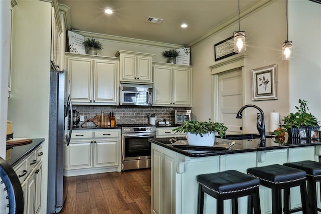 3434 Crampton Gap Way, Norman, OK 73069 - kitchen with stainless steel appliances, dark countertops, a breakfast bar, crown molding, and backsplash
