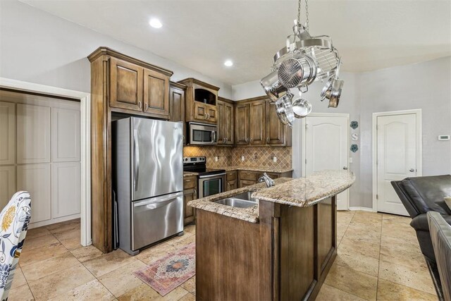 2913 Elmo Way, Oklahoma City, OK 73160 - kitchen featuring stainless steel appliances, backsplash, light stone countertops, an island with sink, and a sink