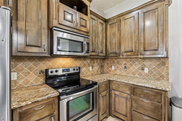 2913 Elmo Way, Oklahoma City, OK 73160 - kitchen with stainless steel appliances, tasteful backsplash, and light stone countertops