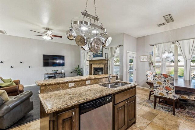 2913 Elmo Way, Oklahoma City, OK 73160 - kitchen with stainless steel dishwasher, open floor plan, a sink, baseboards, and a kitchen island with sink
