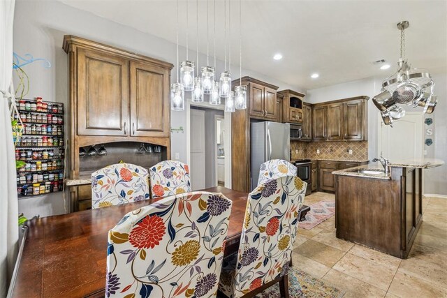 2913 Elmo Way, Oklahoma City, OK 73160 - kitchen featuring appliances with stainless steel finishes, backsplash, a center island with sink, decorative light fixtures, and recessed lighting
