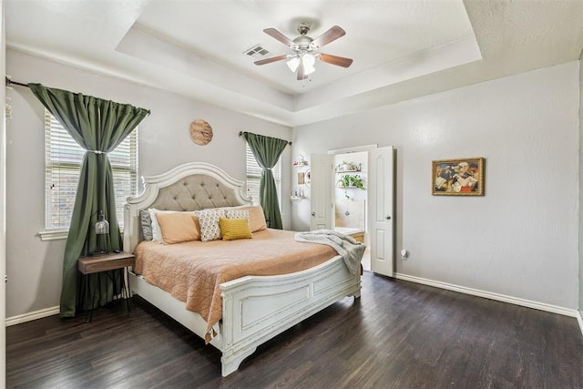 2913 Elmo Way, Oklahoma City, OK 73160 - bedroom with a tray ceiling, baseboards, wood finished floors, and ensuite bath