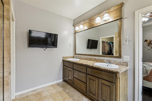 2913 Elmo Way, Oklahoma City, OK 73160 - bathroom with baseboards, double vanity, and a walk in closet
