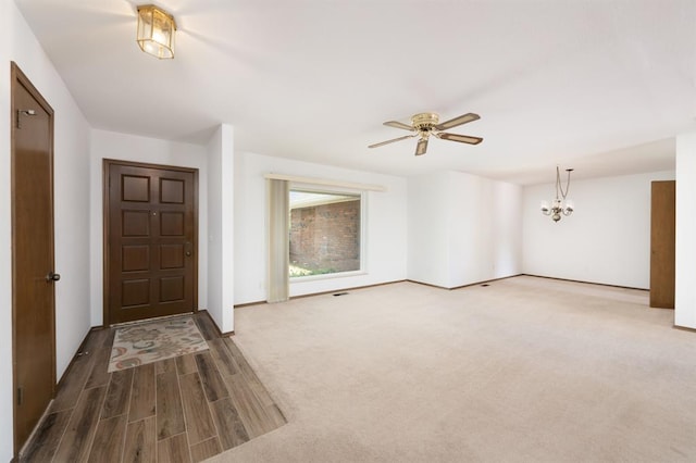3860 Wake Forest Rd, Edmond, OK 73034 - foyer entrance with a ceiling fan, a chandelier, and wood finished floors