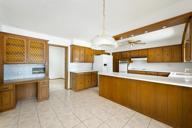 3860 Wake Forest Rd, Edmond, OK 73034 - kitchen with white appliances, under cabinet range hood, brown cabinetry, light countertops, and a peninsula