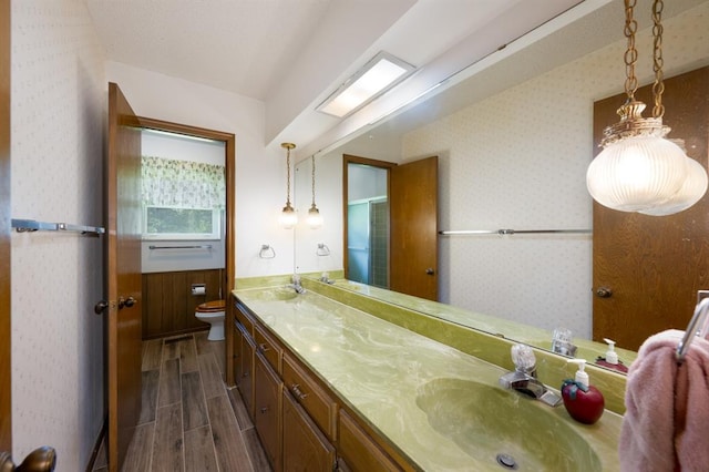 3860 Wake Forest Rd, Edmond, OK 73034 - full bathroom with double vanity, wood finish floors, and wallpapered walls