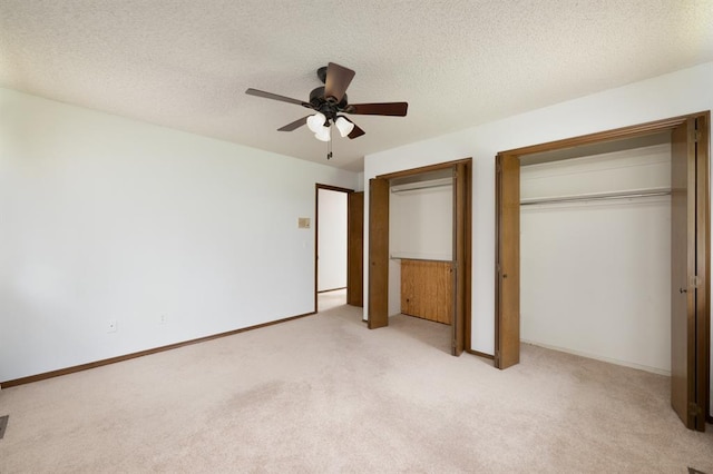 3860 Wake Forest Rd, Edmond, OK 73034 - unfurnished bedroom with multiple closets, light colored carpet, ceiling fan, and a textured ceiling