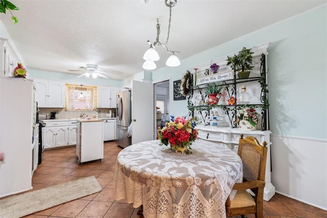 4912 NW 29th St, Oklahoma City, OK 73127 - dining room featuring a ceiling fan, light tile patterned floors, and a textured ceiling