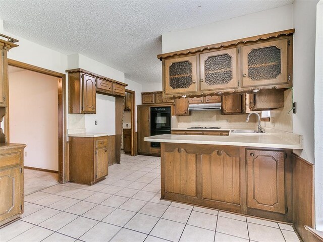 5201 SE 53rd St, Oklahoma City, OK 73135 - kitchen featuring a sink, a peninsula, under cabinet range hood, backsplash, and light countertops