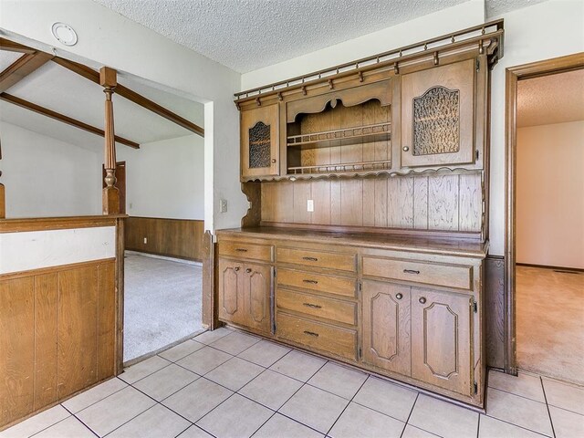 5201 SE 53rd St, Oklahoma City, OK 73135 - kitchen featuring light colored carpet, a wainscoted wall, a textured ceiling, wood walls, and light tile patterned flooring