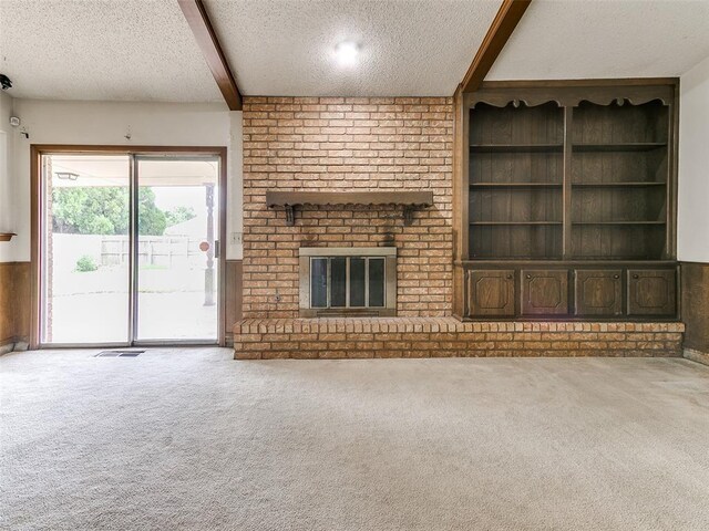 5201 SE 53rd St, Oklahoma City, OK 73135 - unfurnished living room with a textured ceiling, carpet floors, a brick fireplace, and beam ceiling