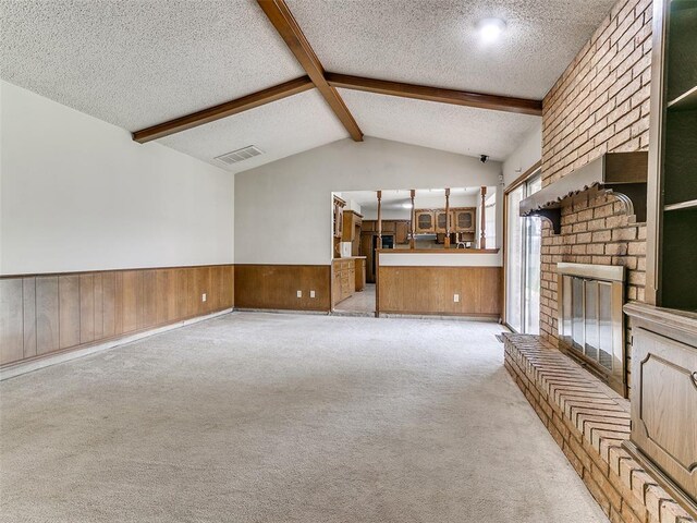 5201 SE 53rd St, Oklahoma City, OK 73135 - unfurnished living room featuring a textured ceiling, wood walls, wainscoting, light colored carpet, and a brick fireplace