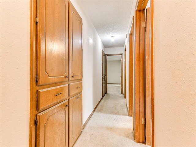 5201 SE 53rd St, Oklahoma City, OK 73135 - hall featuring light carpet, a textured ceiling, and a textured wall