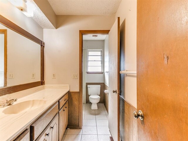5201 SE 53rd St, Oklahoma City, OK 73135 - bathroom featuring vanity, a wainscoted wall, toilet, tile patterned floors, and a textured ceiling