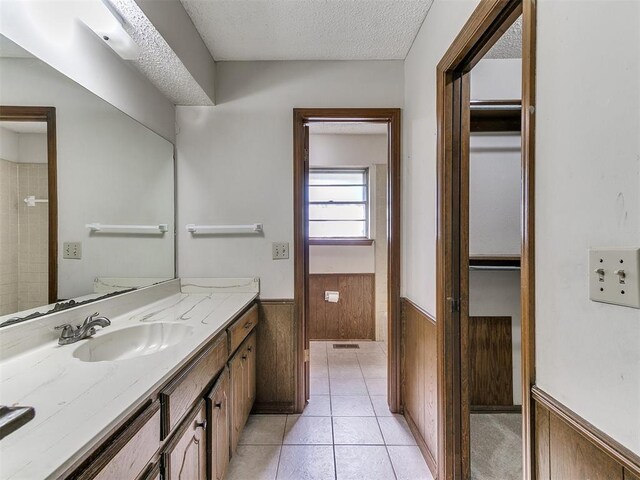 5201 SE 53rd St, Oklahoma City, OK 73135 - full bath featuring wainscoting, vanity, a textured ceiling, tile patterned flooring, and wooden walls