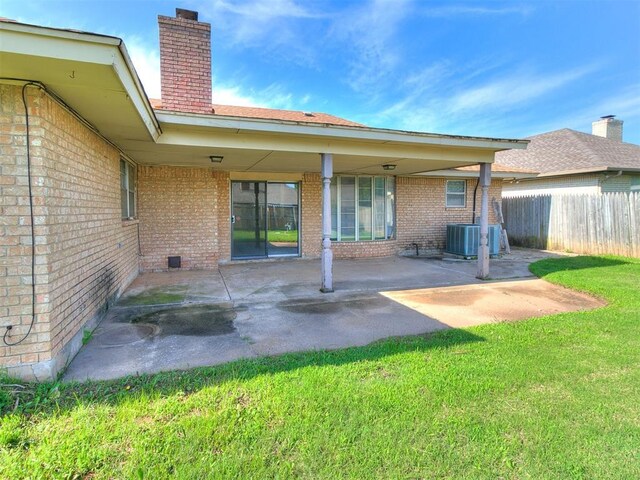 5201 SE 53rd St, Oklahoma City, OK 73135 - rear view of property featuring brick siding, a chimney, central AC, and a patio