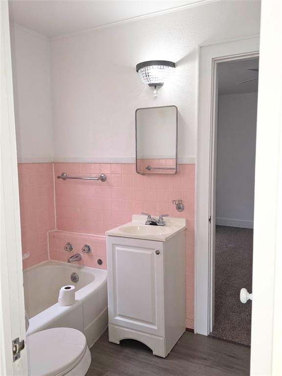 926 S 9th St, Chickasha, OK 73018 - full bathroom with tile walls, vanity, wood finished floors, a bath, and a wainscoted wall