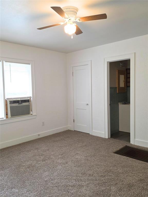 926 S 9th St, Chickasha, OK 73018 - unfurnished bedroom with cooling unit, carpet flooring, and a ceiling fan